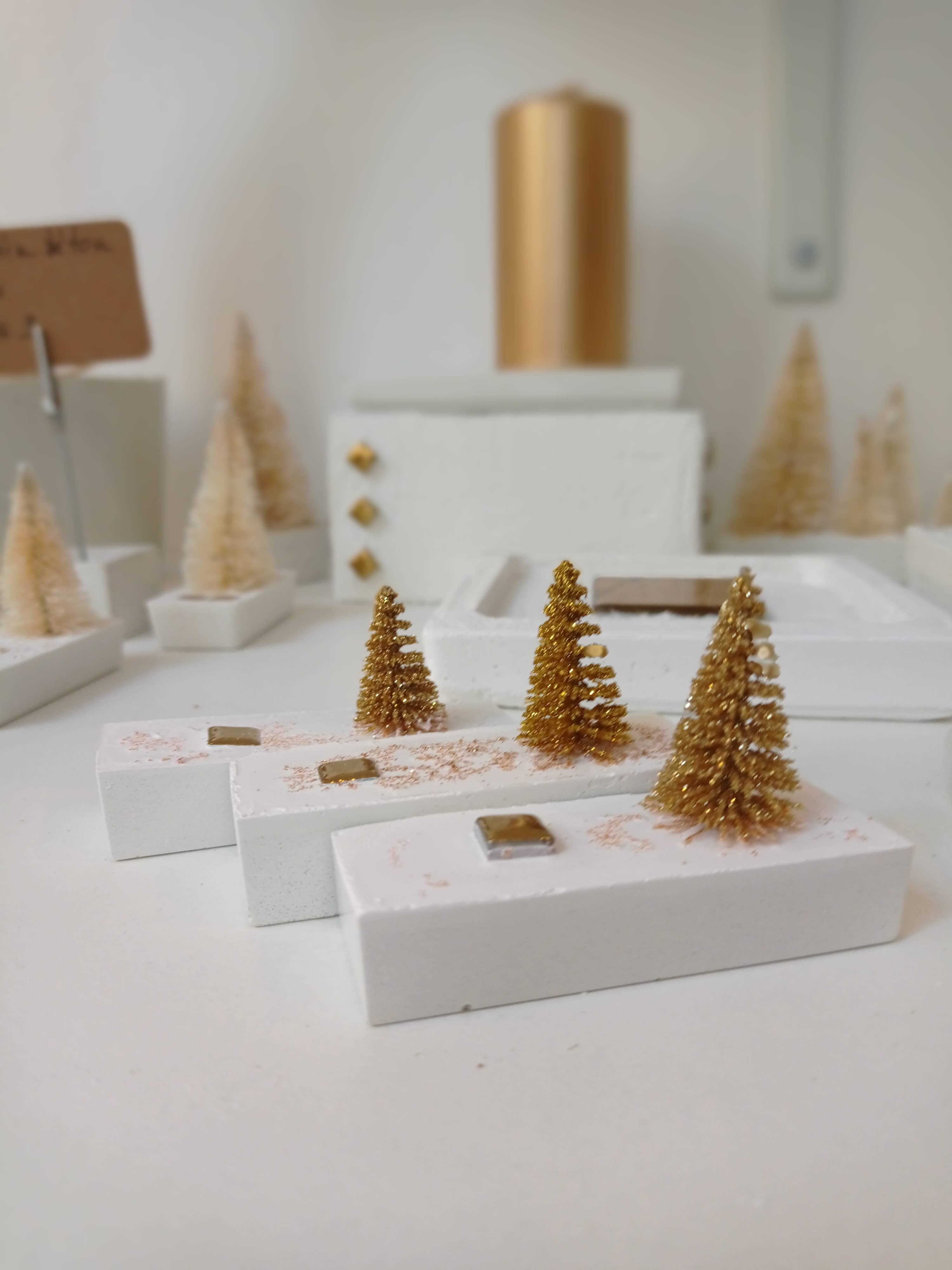 Mini-kerstboomversiering op witte betonnen sokkel